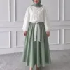 Button Chemise blanche portée avec une jupe longue vert sauge (jupe non incluse)