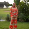 Santorini Set Céléria orange, ensemble femme modeste en satin imprimé, chemise ample et pantalon large, dans le jardin